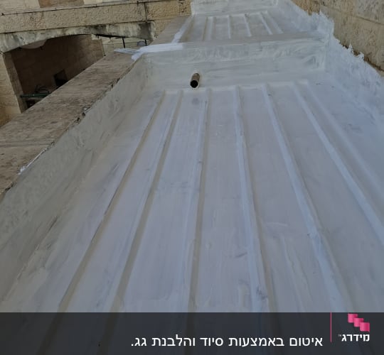 גג אטום בלבן עם צינור בולט מהקיר